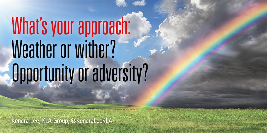 Bright rainbow in grassy field with blue sky breaking through storm clouds