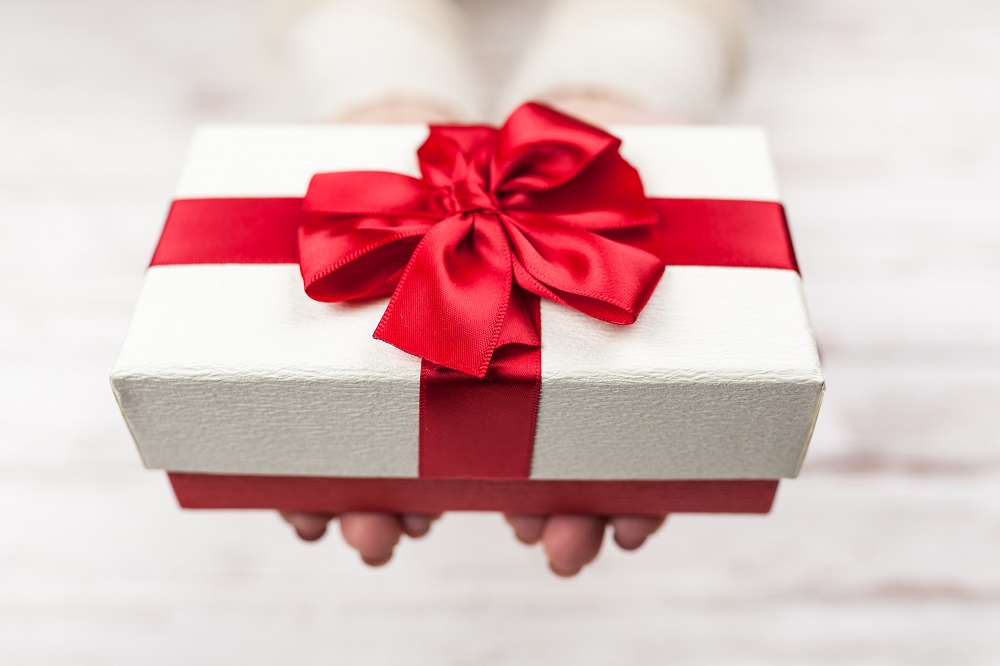 Person giving the gift of hitting Q4 sales goals