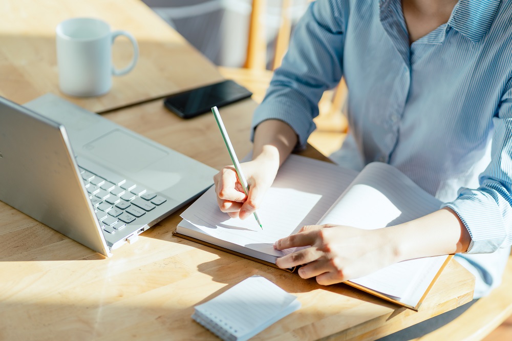 woman handwriting marketing messages in a notebook